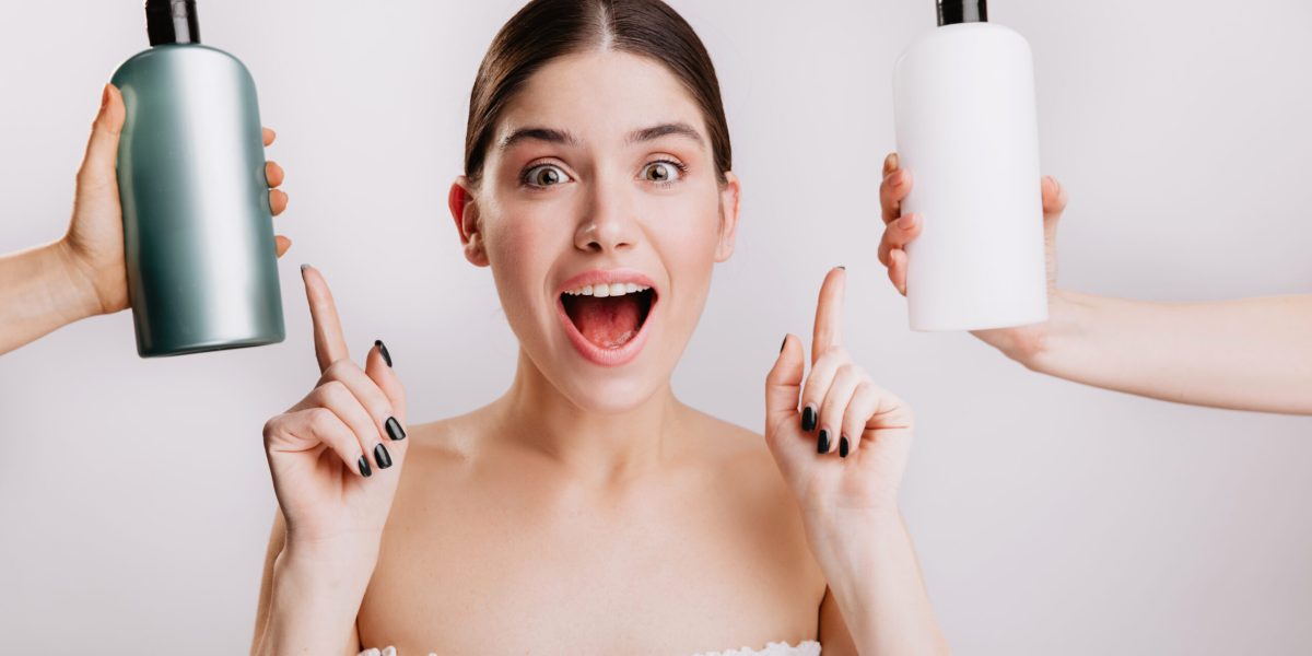 Closeup portrait of joyful girl posing without makeup on white background. Woman chose which shampoo is best to use