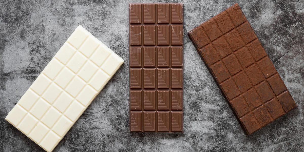 composicao-criativa-de-chocolate-plana-leiga-em-fundo-escuro