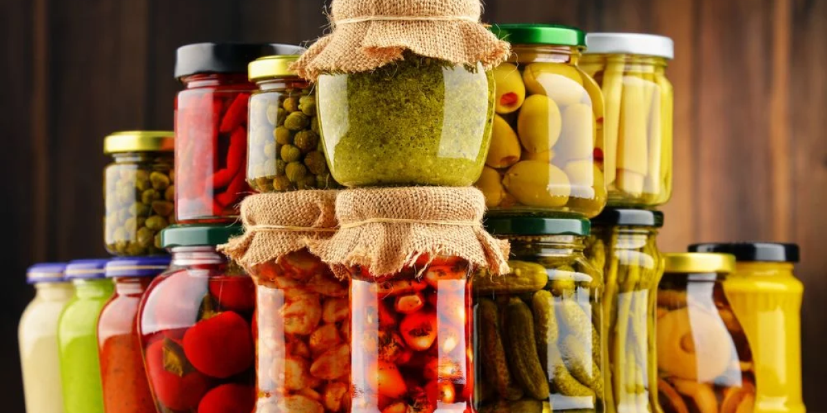 vários frascos de vidro com alimentos conservados em conserva e picles empilhados em uma superfície