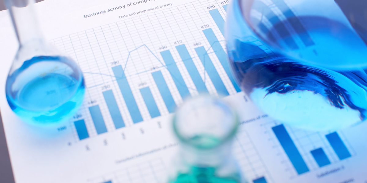 Test-tubes with blue liquids over business document