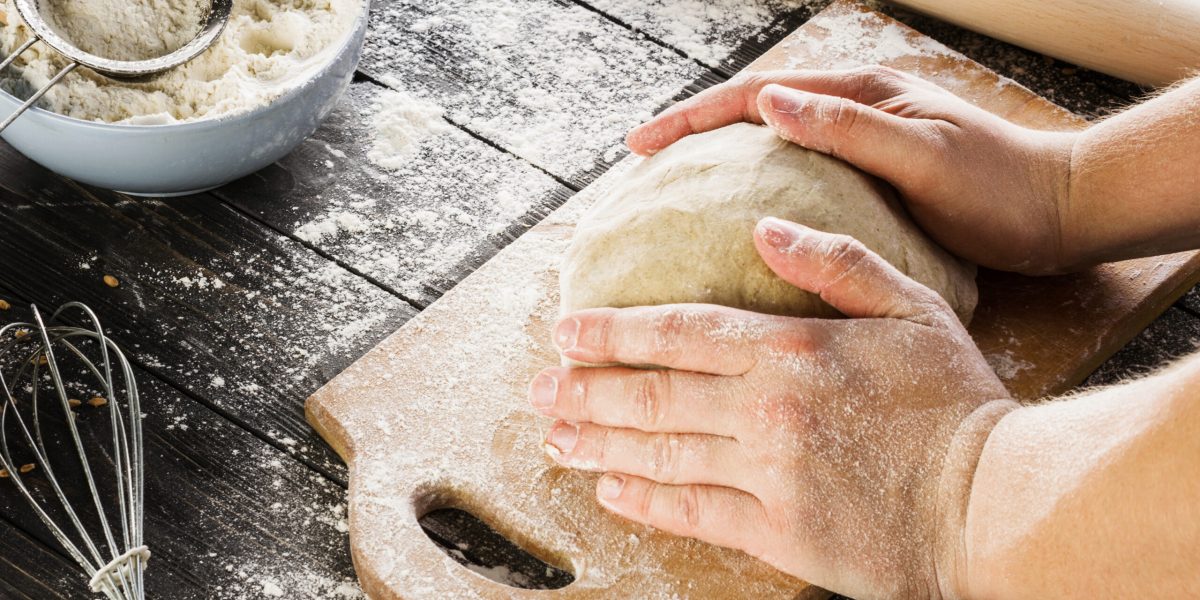 macho-maos-amassar-massa-polvilhada-com-mesa-de-farinha