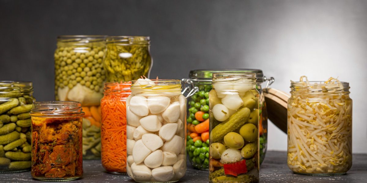 vista-frontal-de-uma-variedade-de-vegetais-em-conserva-em-potes-de-vidro-transparente